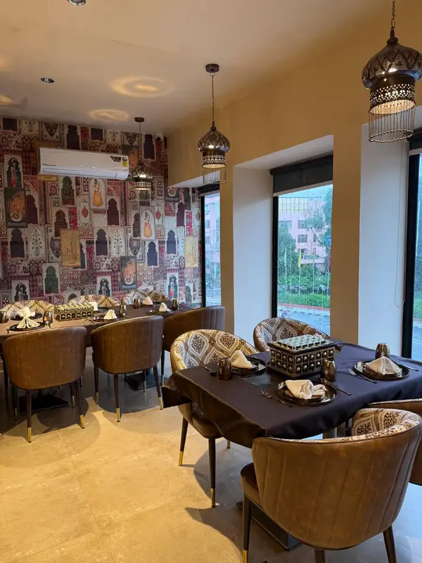 Tall windows, patterned walls and velvet chairs. Tajnuma, Agra.